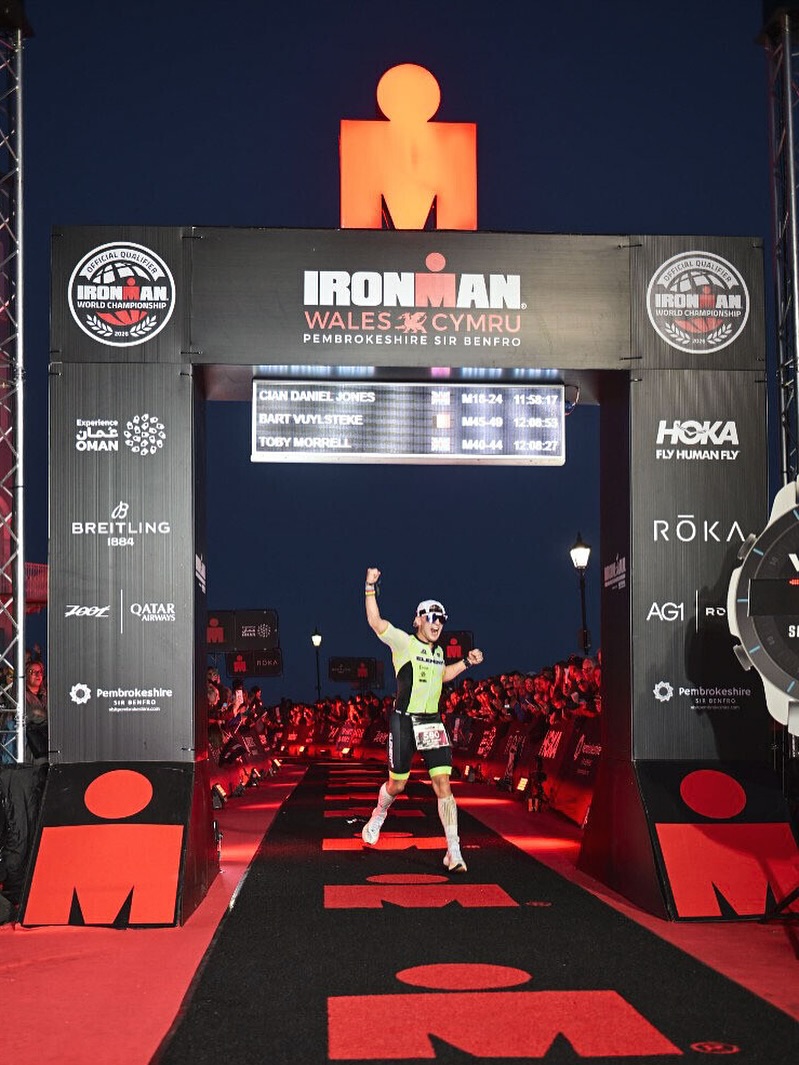 Cian Daniel Jones crossing the finish line at Ironman Wales 2025